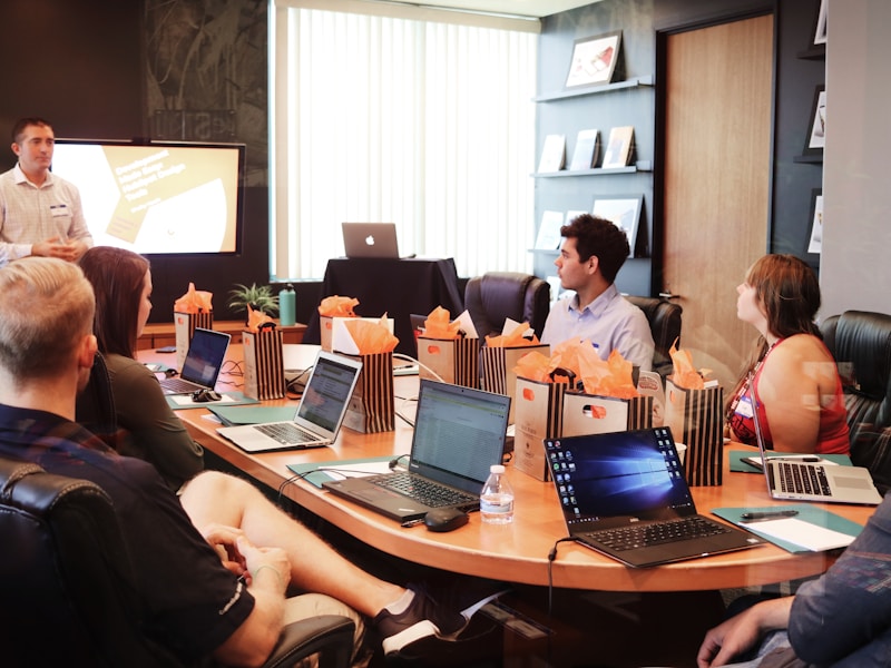 A small room of business owners working through a session on laptops